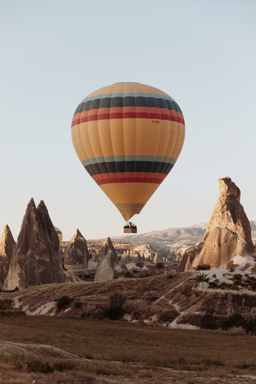 hot air balloon on mid air above rock formation
